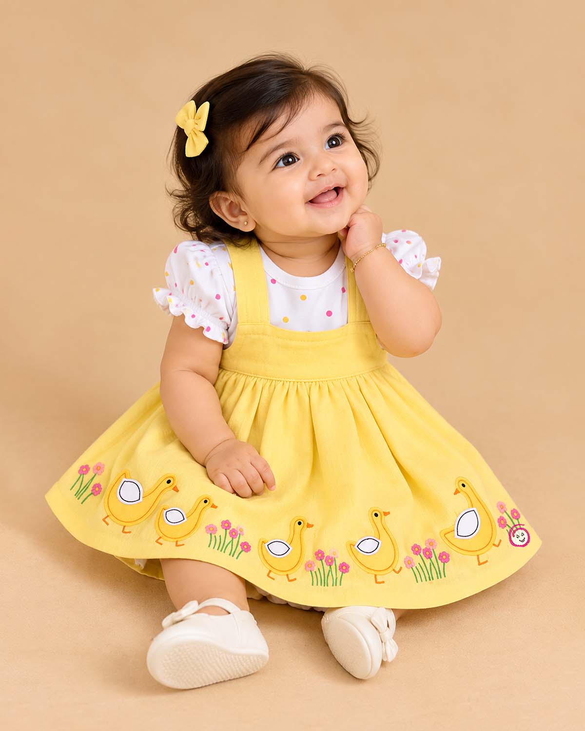 Baby girl in a lemon check pinafore